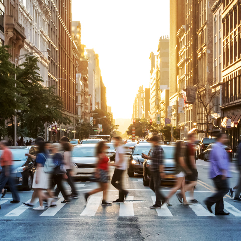 Blurred image of people crossing wide new york road in summer clothing