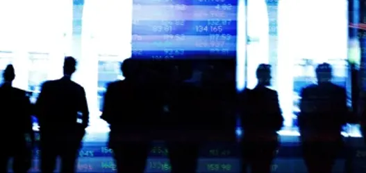 Silhouttes of people stood infront of abstract financial listings board