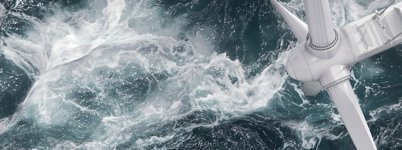 Overhead view of offshore wind turbine with waves crashing around