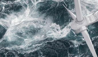 Overhead view of offshore wind turbine with waves crashing around