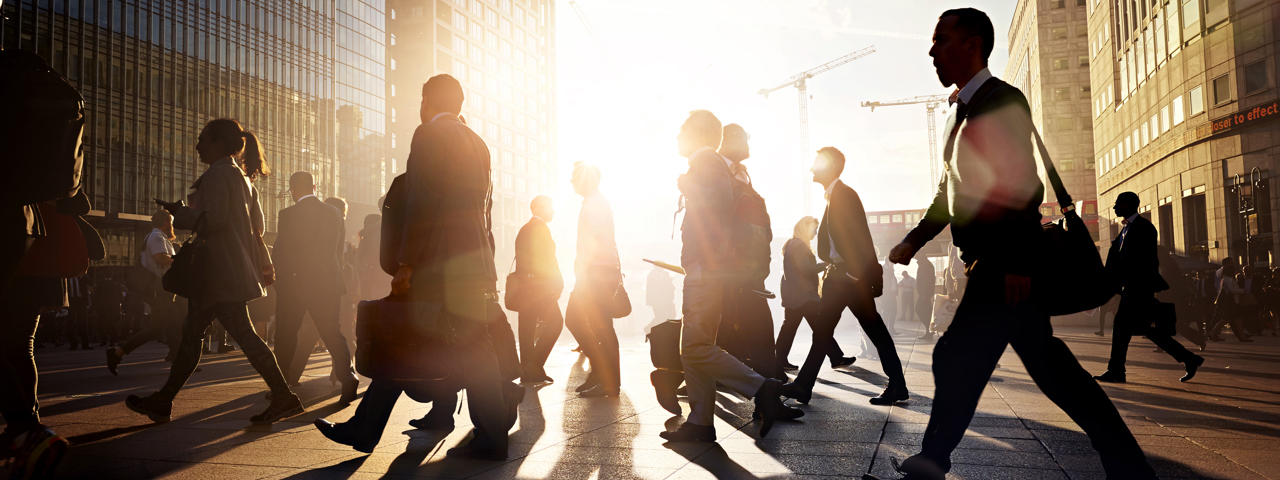 Business people walking in city during sunrise