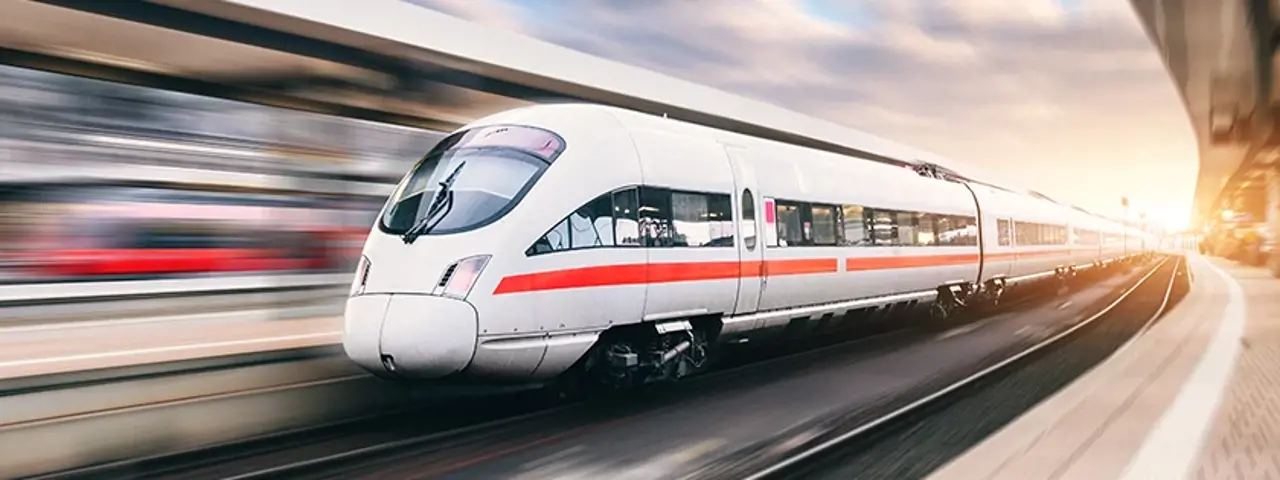 White and red train moving through station nexy to platform